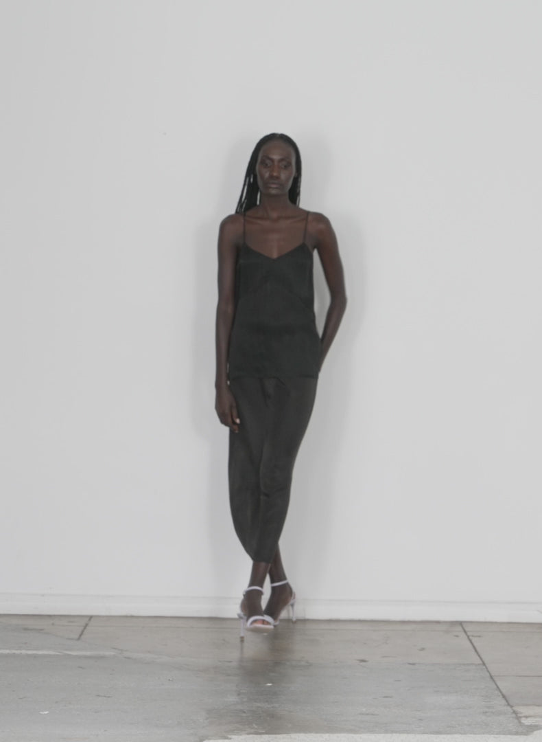 Model wearing the the slip cami black walking forward and turning around