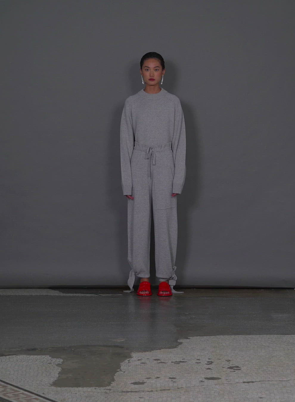 Model wearing the cashmere tie lounge sweatpants walking forward and turning around