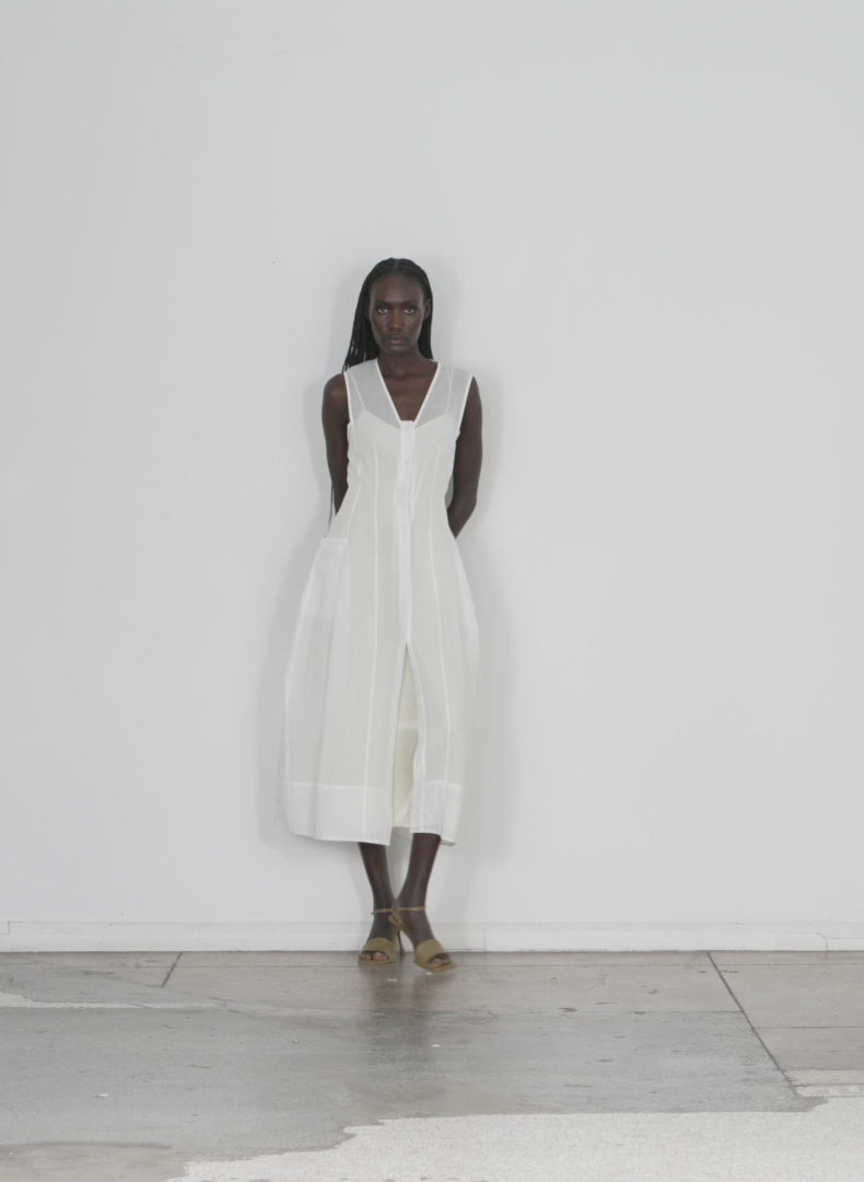 Model wearing the starch cotton organza dress white walking forward and turning around