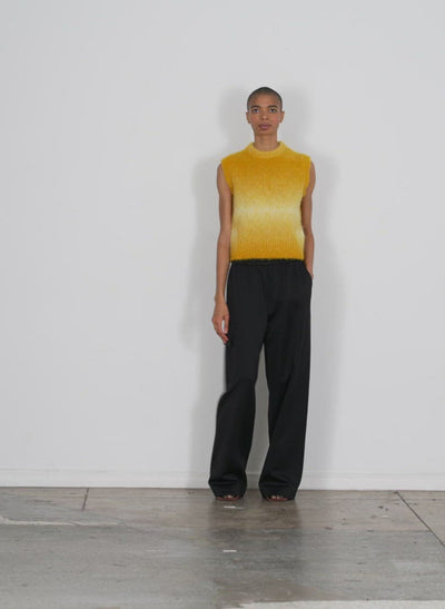 Model wearing the ombre superfine alpaca shrunken cutoff vest yellow multi walking forward and turning around