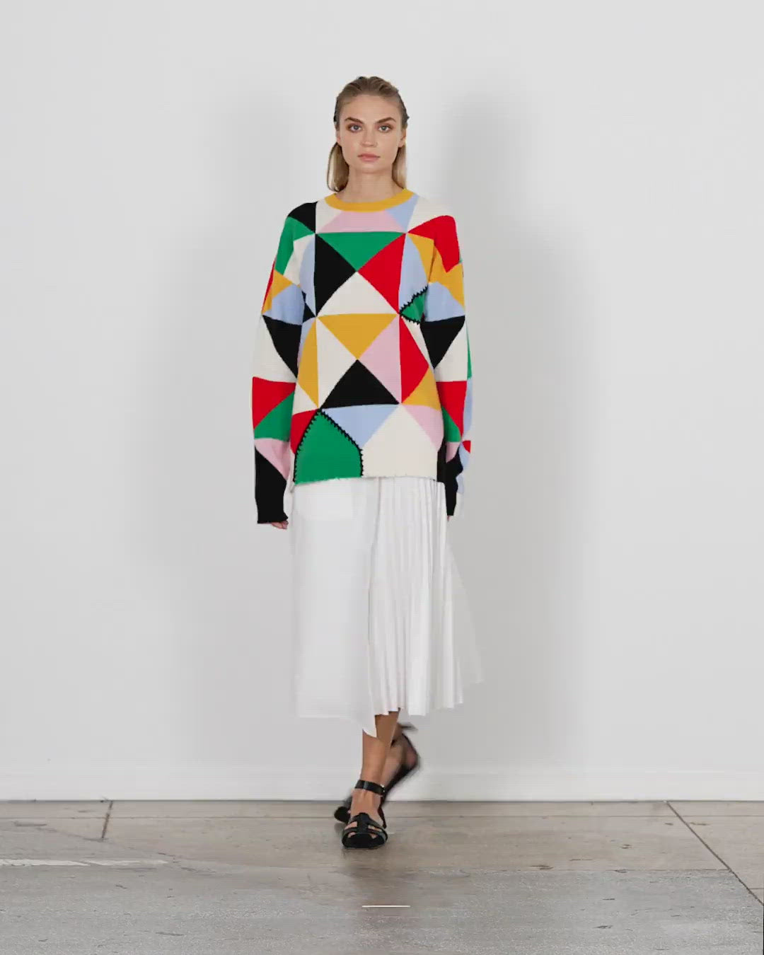 Model wearing the patchwork intarsia sweater walking forward and turning around