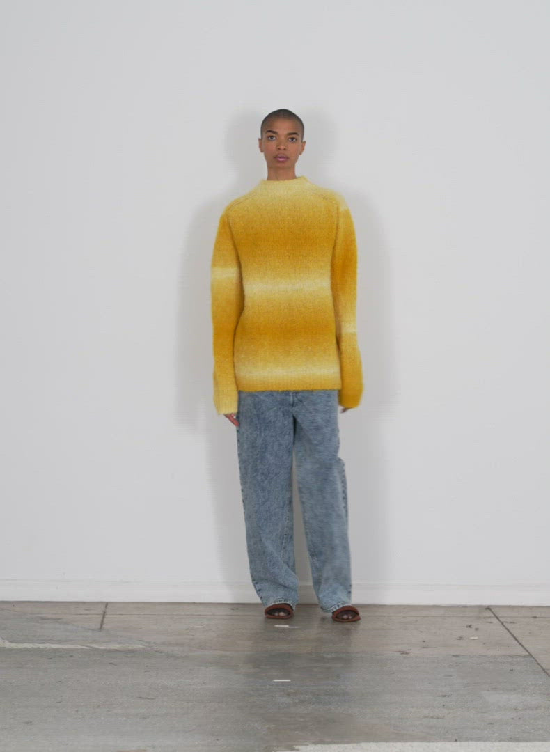 Model wearing the ombre superfine alpaca funnel neck pullover yellow multi walking forward and turning around