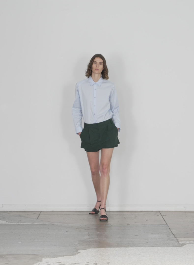 Model wearing the arun suiting double layer mini hazel green walking forward and turning around