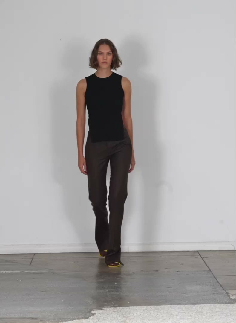 Model wearing the reed suiting elfie petite trouser w slits brown multi walking forward and turning around