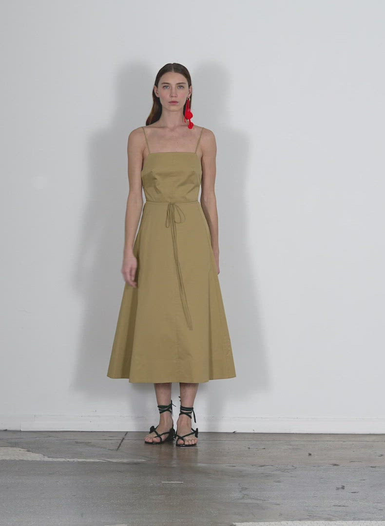 Model wearing the eco poplin strappy dress khaki walking forward and turning around