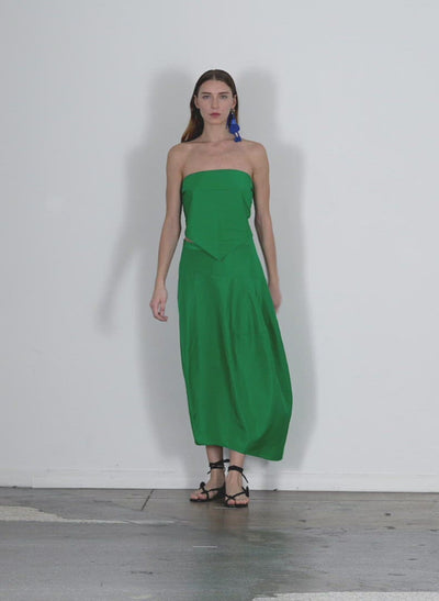 Model wearing the italian sporty nylon asymmetrical balloon skirt green walking forward and turning around