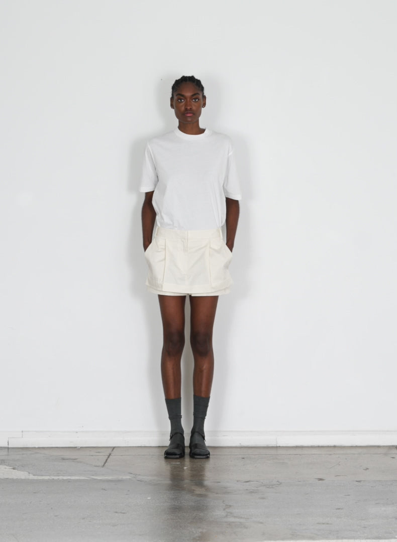 Model wearing the eco poplin double layer mini cream walking forward and turning around