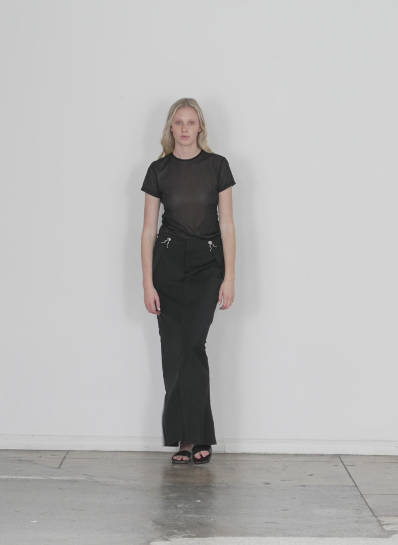 Model wearing the dominic pinstripe overall skirt black white multi walking forward and turning around