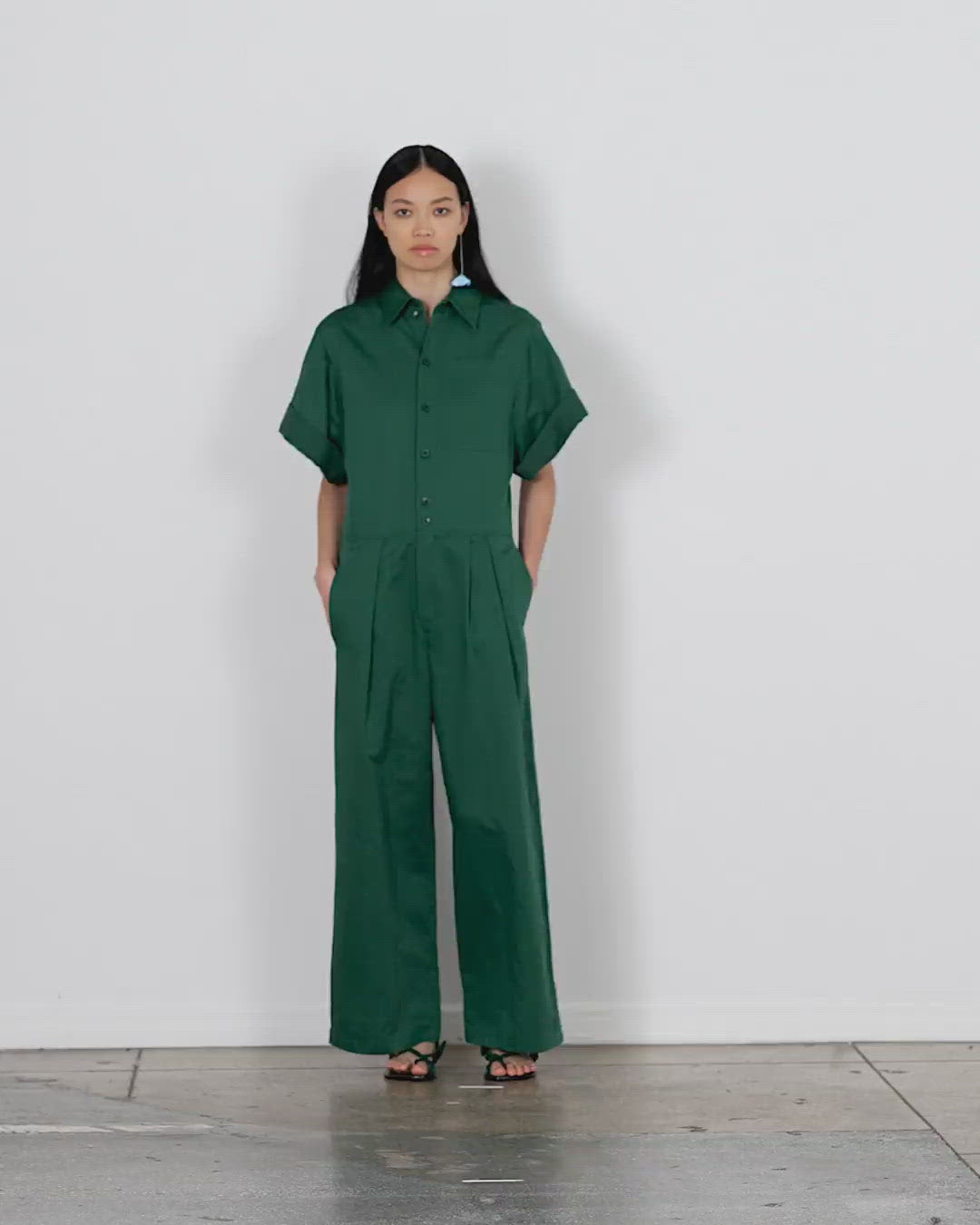 Model wearing the cotton linen sateen jumpsuit walking forward and turning around