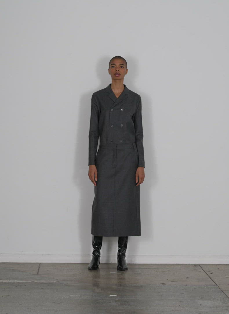 Model wearing the superfine wool midi trouser skirt navy walking forward and turning around