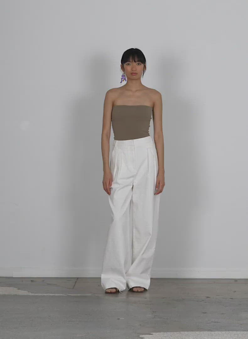 Model wearing the white denim stella full length pant walking forward and turning around