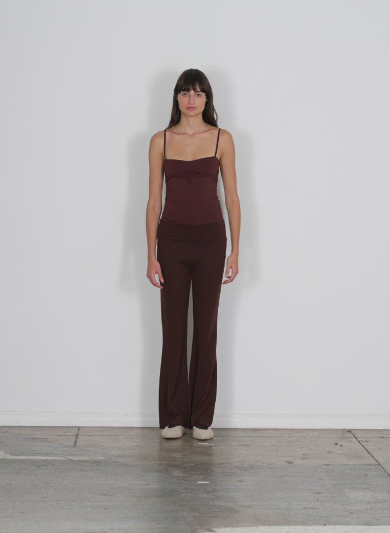 Model wearing the wool jersey ali fluid pant brown walking forward and turning around