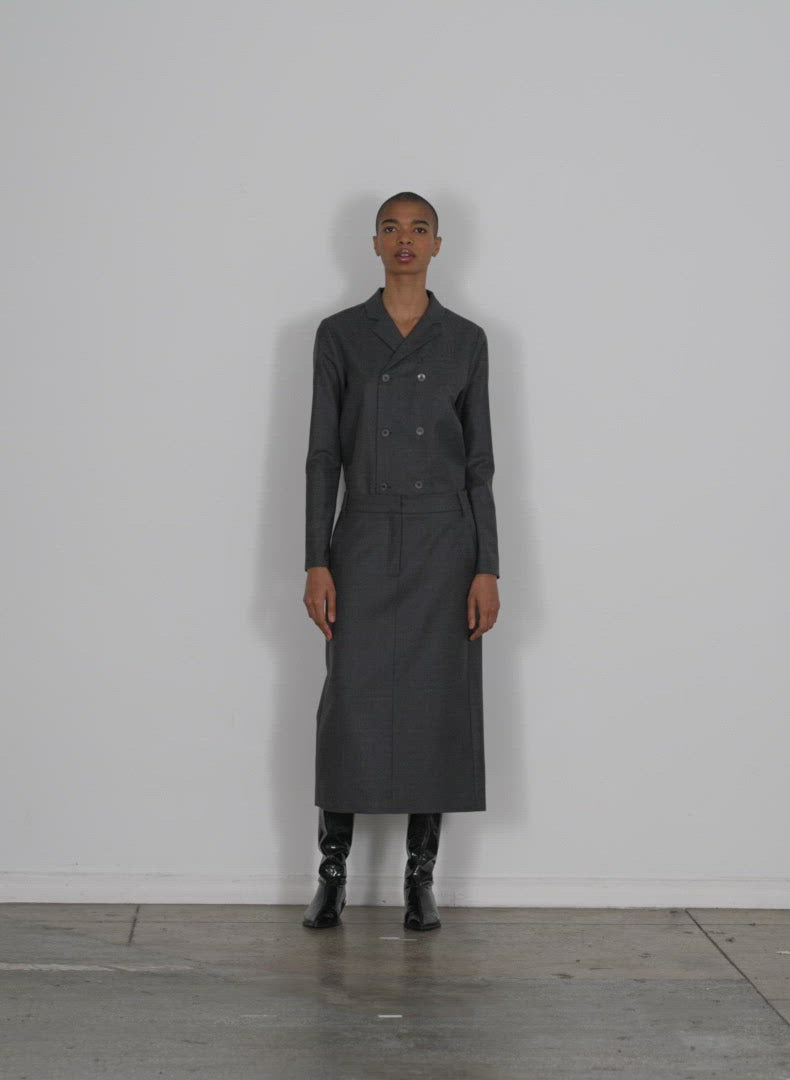 Model wearing the superfine wool midi trouser skirt medium heather grey walking forward and turning around