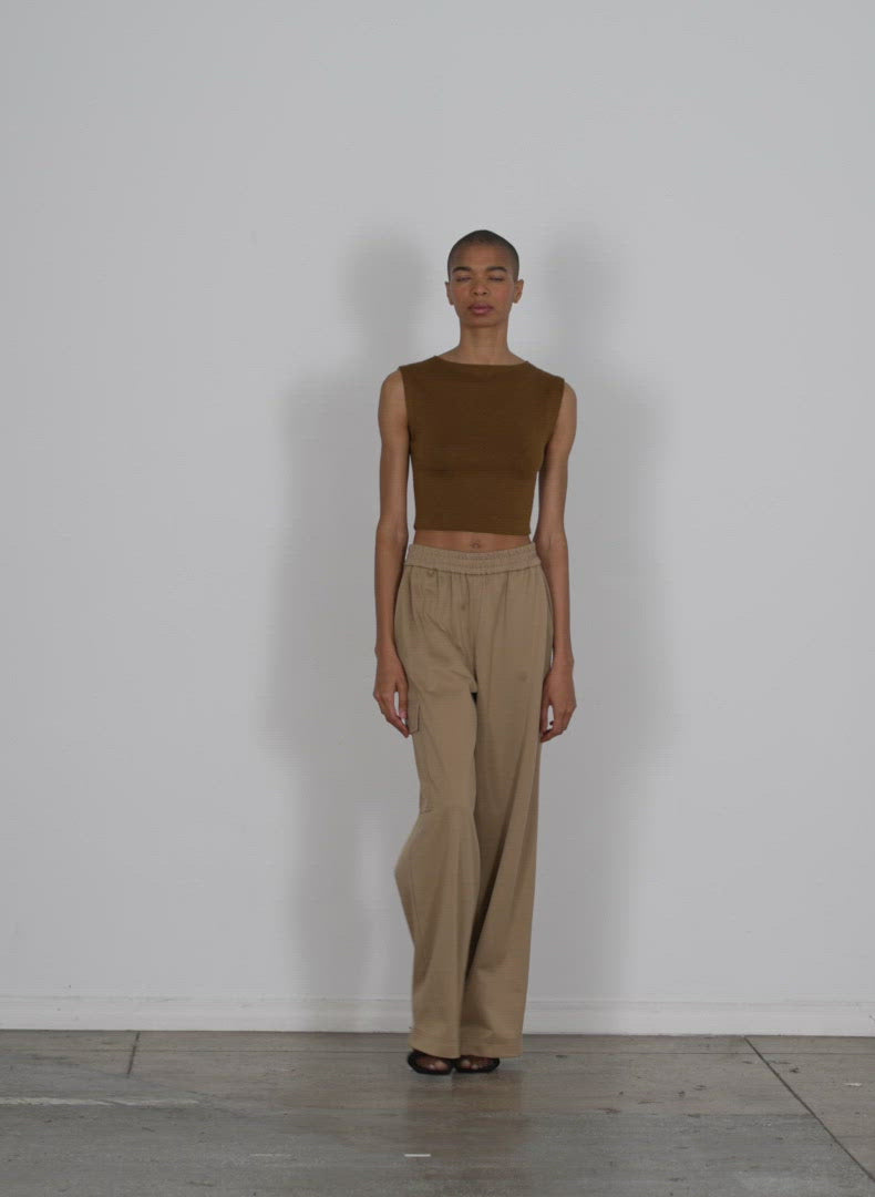 Model wearing the organic cotton tencel tube cropped tank dark mustard walking forward and turning around