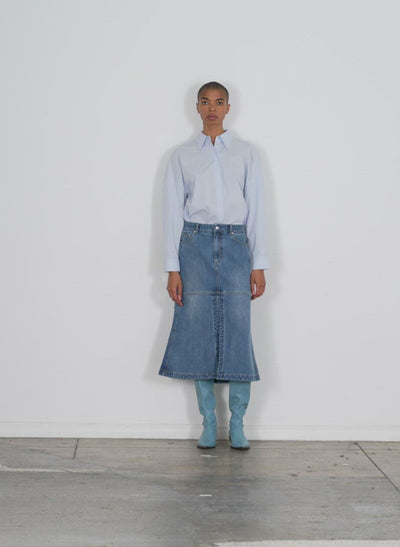 Model wearing the classic wash denim skirt classic blue walking forward and turning around