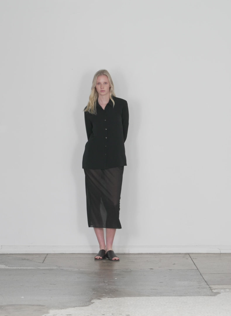 Model wearing the sheer gauze maxi pencil skirt black walking forward and turning around