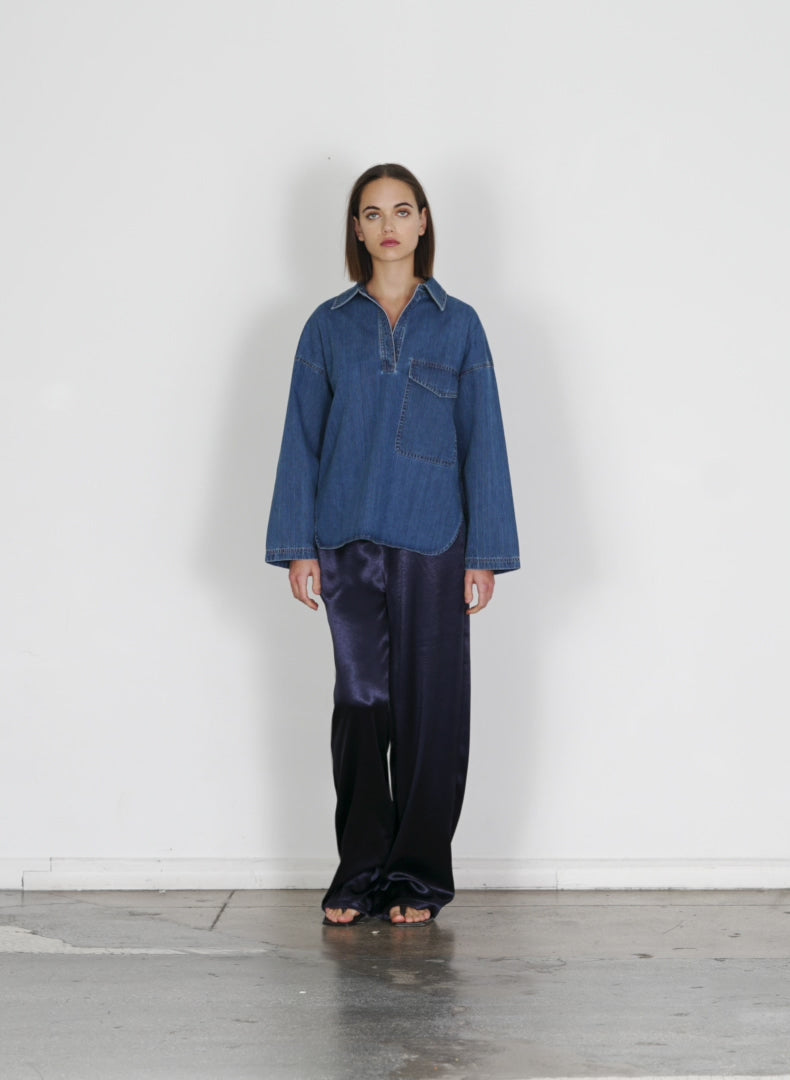 Model wearing the stone washed summer denim oversized cocoon shirt medium stone wash walking forward and turning around