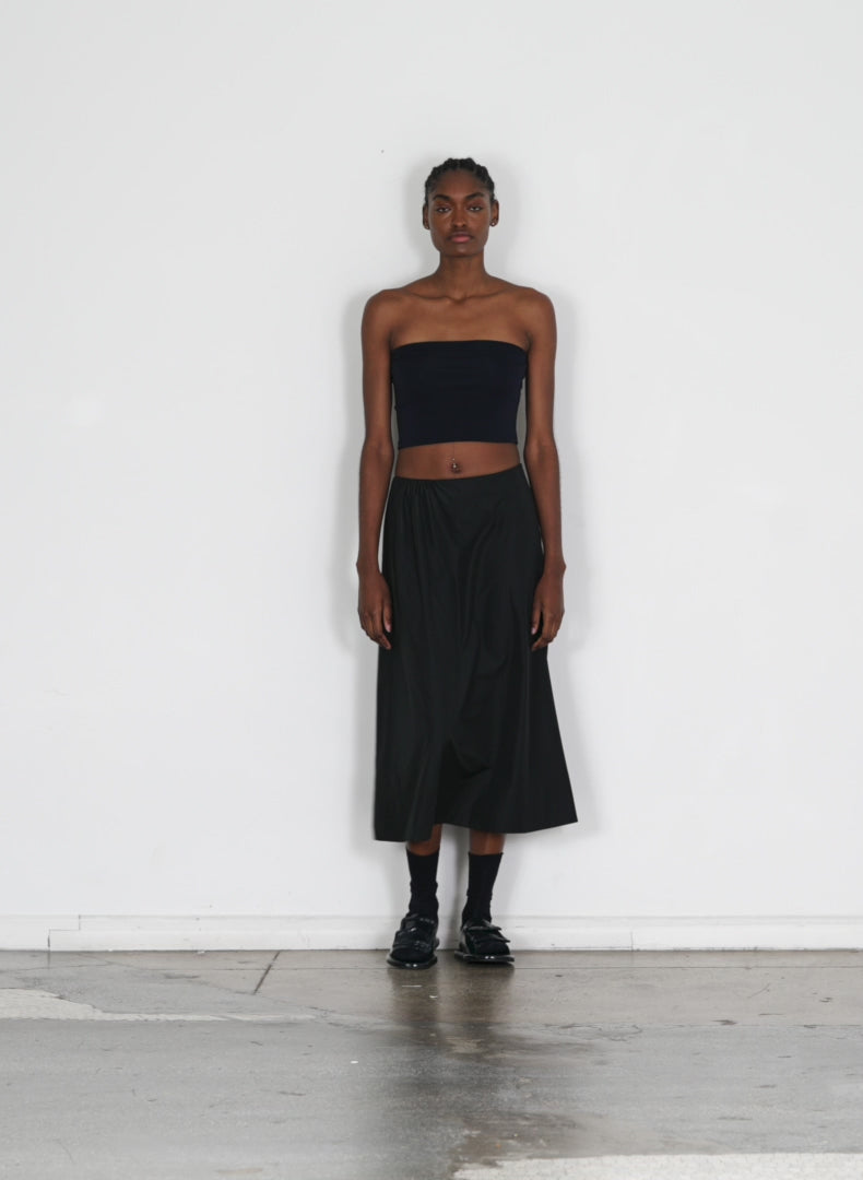 Model wearing the italian sporty nylon side shirred circle skirt black walking forward and turning around