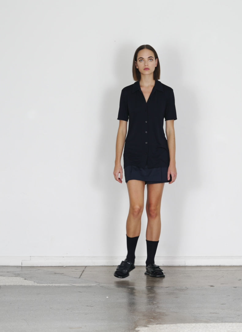 Model wearing the eco poplin double layer mini dark navy walking forward and turning around