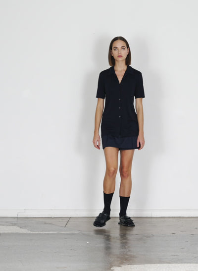 Model wearing the eco poplin double layer mini dark navy walking forward and turning around