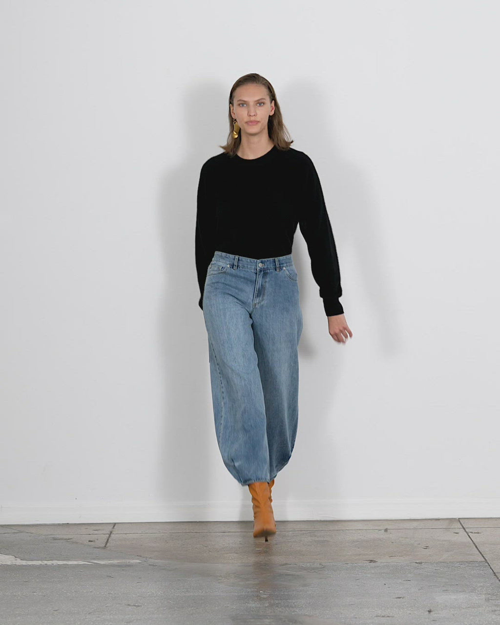 Model wearing the classic wash denim long brancusi jeanrancusi jean walking forward and turning around