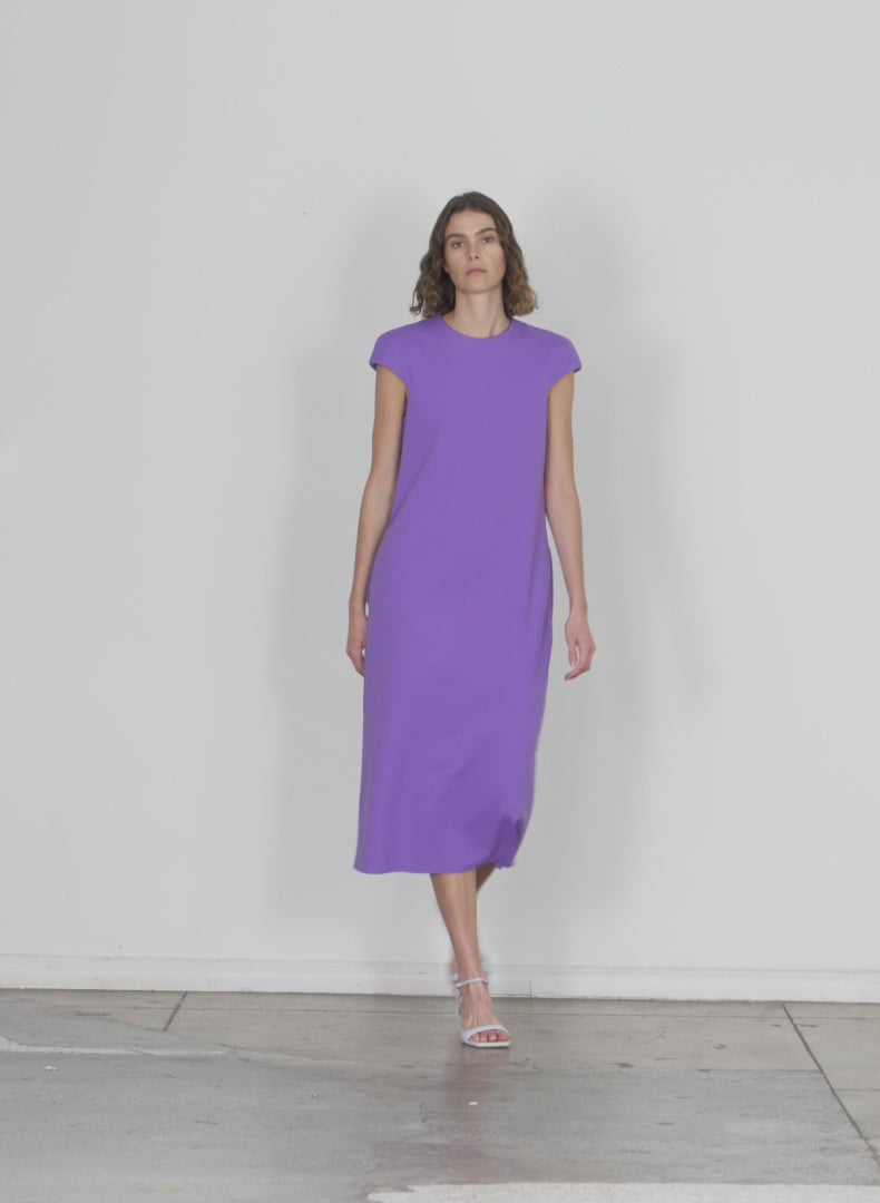 Model wearing the compact ultra stretch knit lean sleeveless dress violet walking forward and turning around