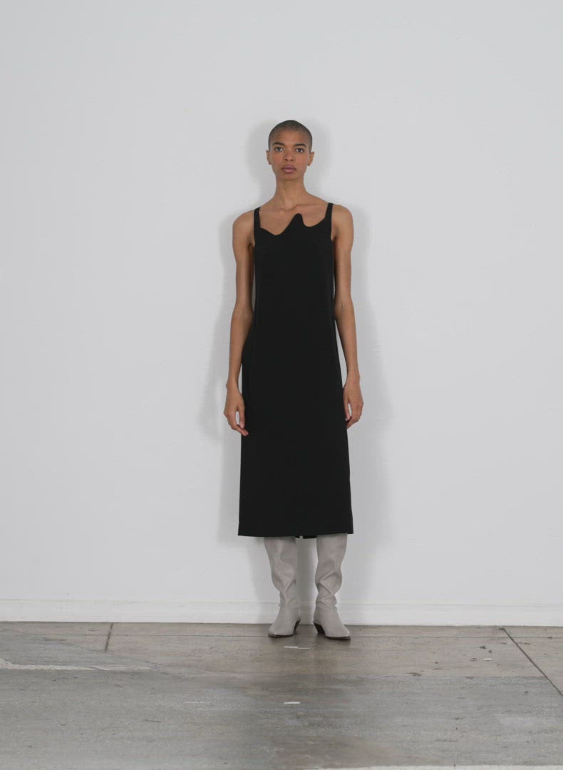 Model wearing the fluid drape squiggly dress black walking forward and turning around