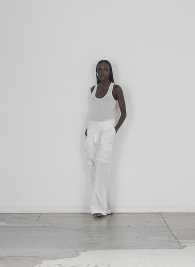 Model wearing the crepe gauze racerback tank white walking forward and turning around