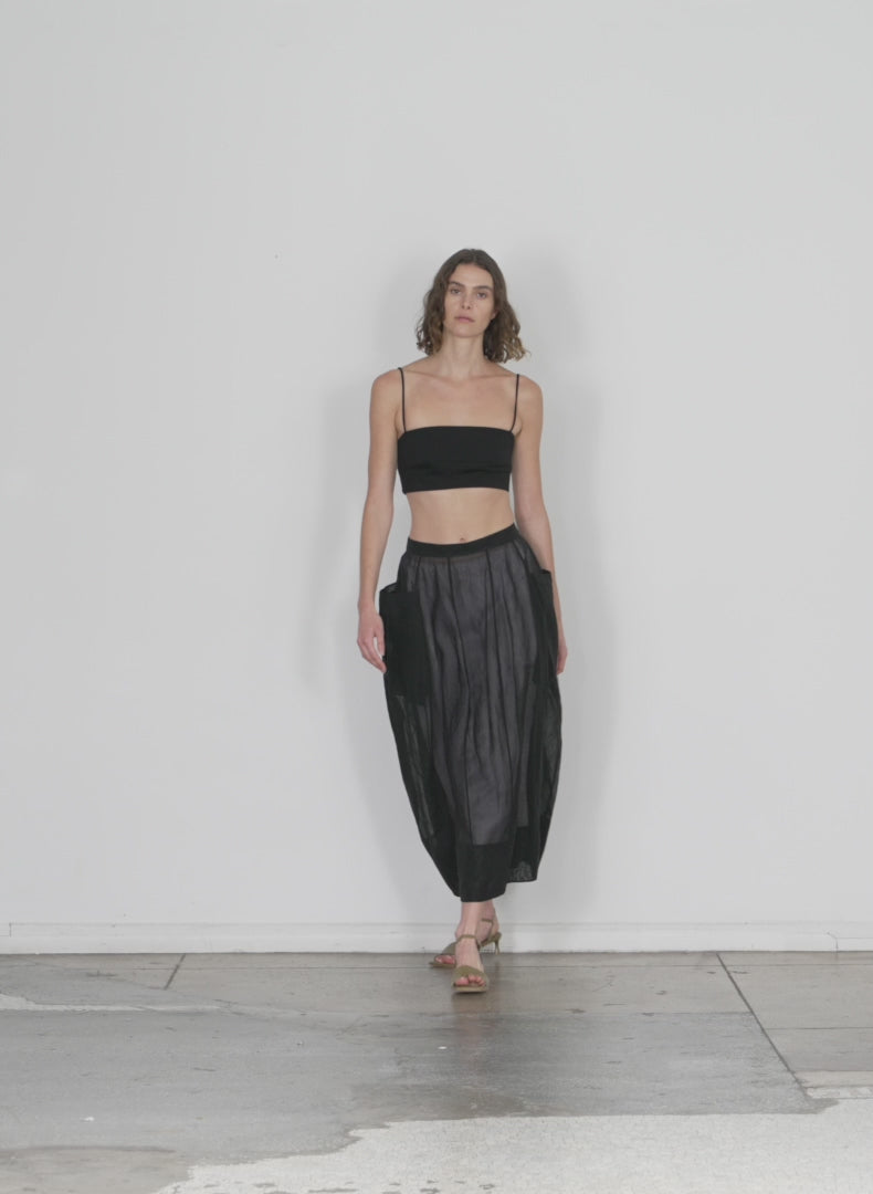 Model wearing the starch cotton organza lantern skirt black walking forward and turning around