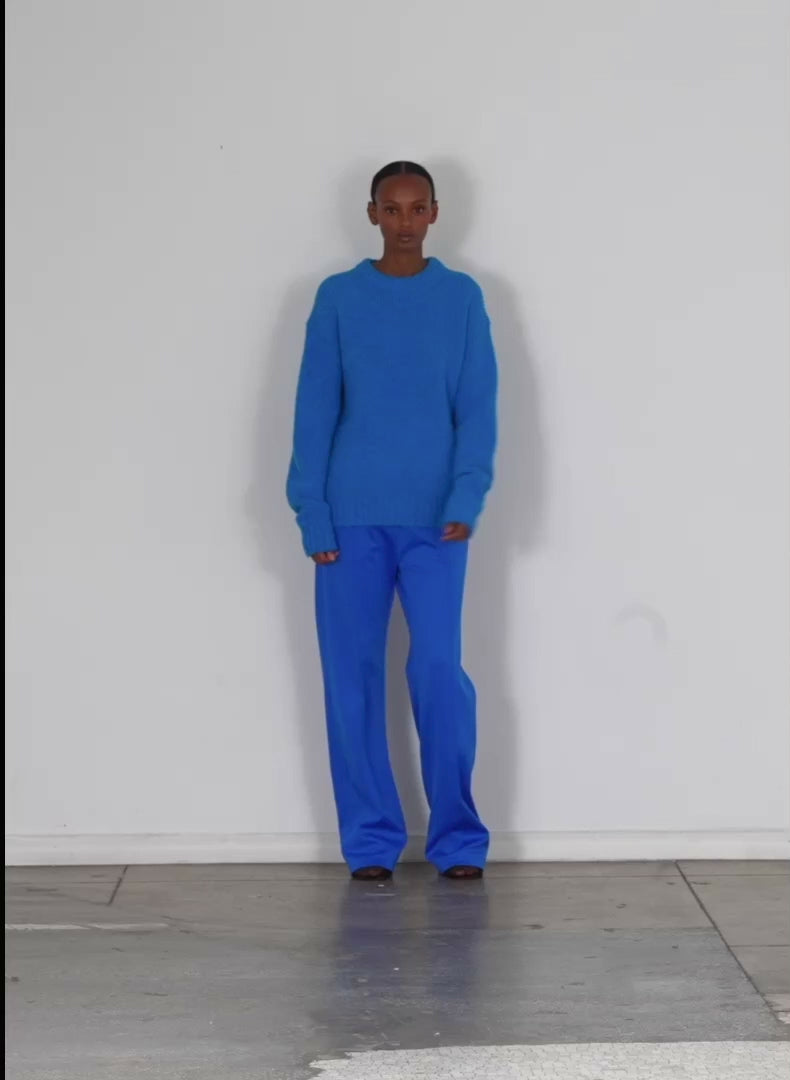 Model wearing the airy alpaca crewneck pullover sapphire blue walking forward and turning around
