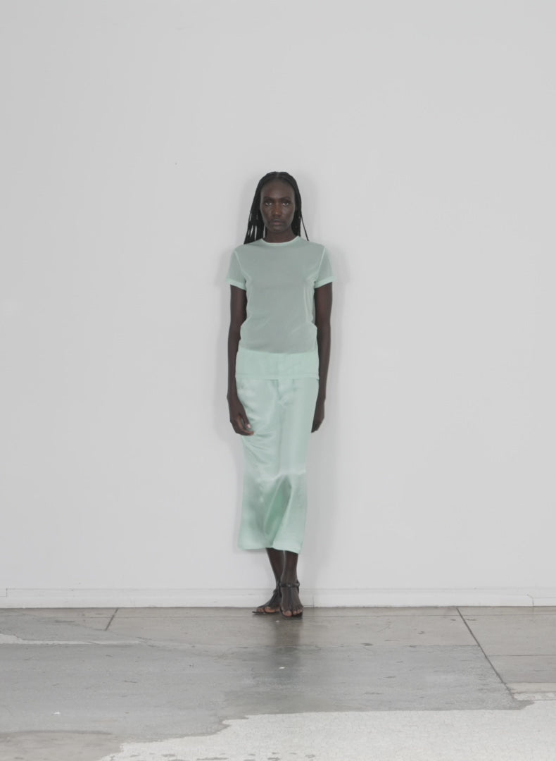 Model wearing the sheer gauze baby t mint walking forward and turning around