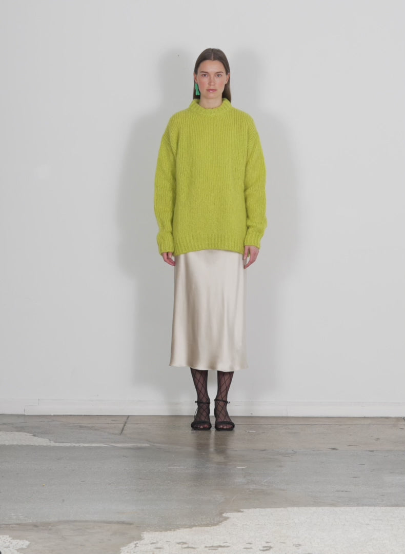 Model wearing the claude mohair crewneck easy pullover lime green walking forward and turning around