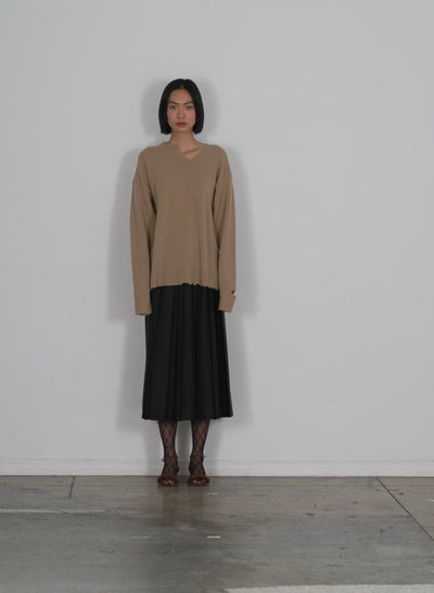 Model wearing the soft lambswool cutout neckband pullover sand walking forward and turning around