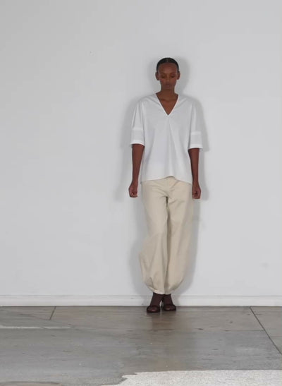 Model wearing the eco poplin vneck cocoon top white walking forward and turning around