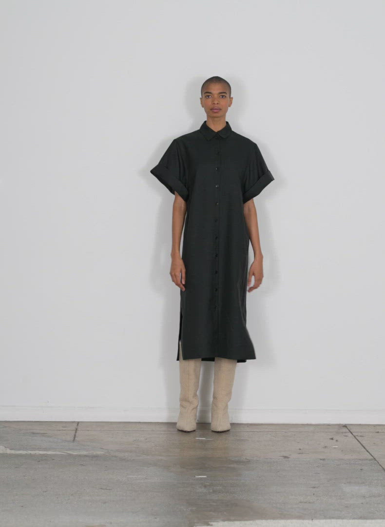 Model wearing the devin light weight tech twill rolled slv shirtdres black walking forward and turning around