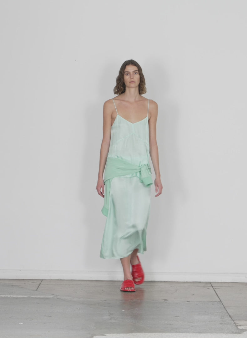Model wearing the the slip skirt mint walking forward and turning around