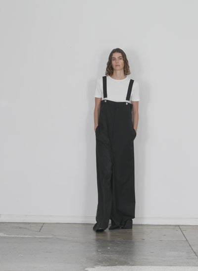 Model wearing the dominic pinstripe overall wide leg pant black white multi walking forward and turning around