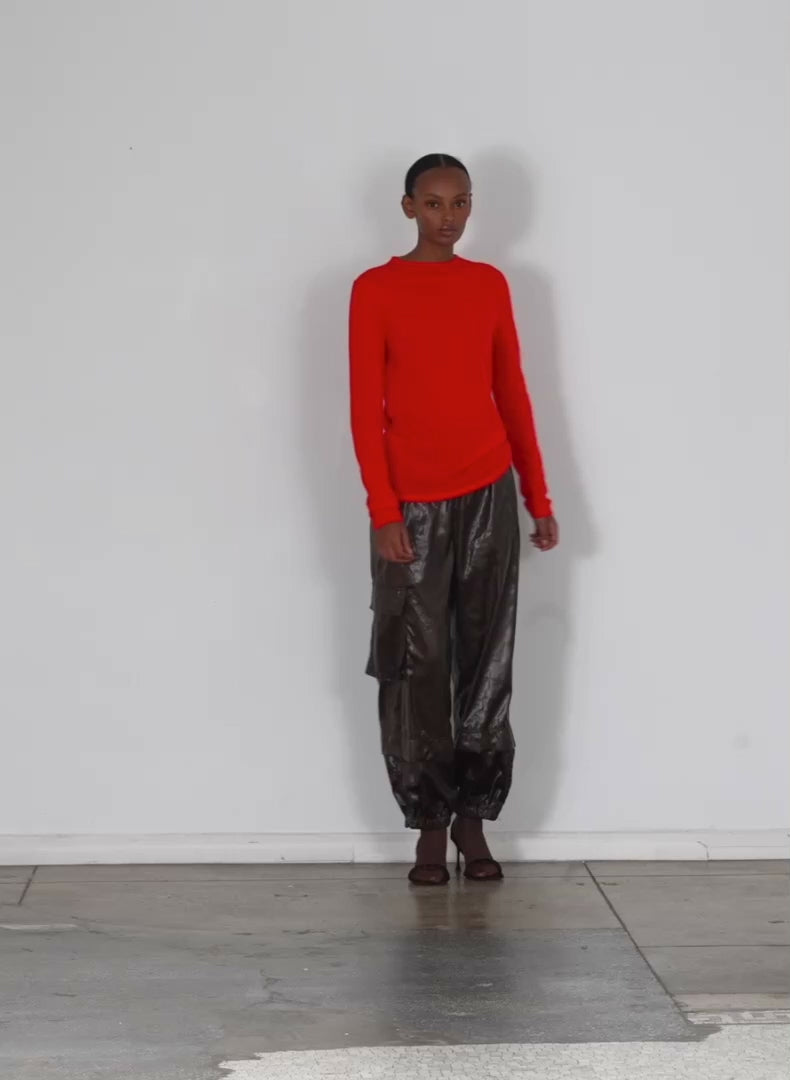 Model wearing the skinlike mercerized wool soft sheer pullover red walking forward and turning around