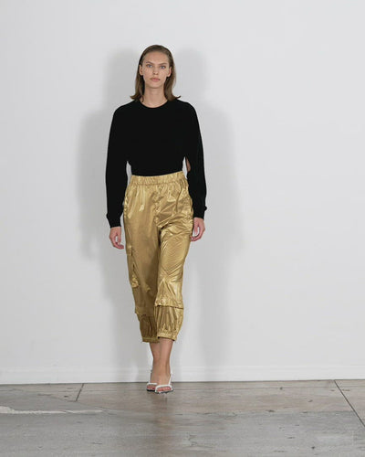 Model wearing the metallic nylon wilt pull on jogger gold walking forward and turning around