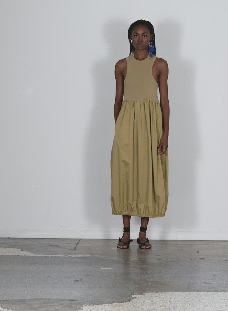 Model wearing the ribbed tank balloon dress khaki walking forward and turning around