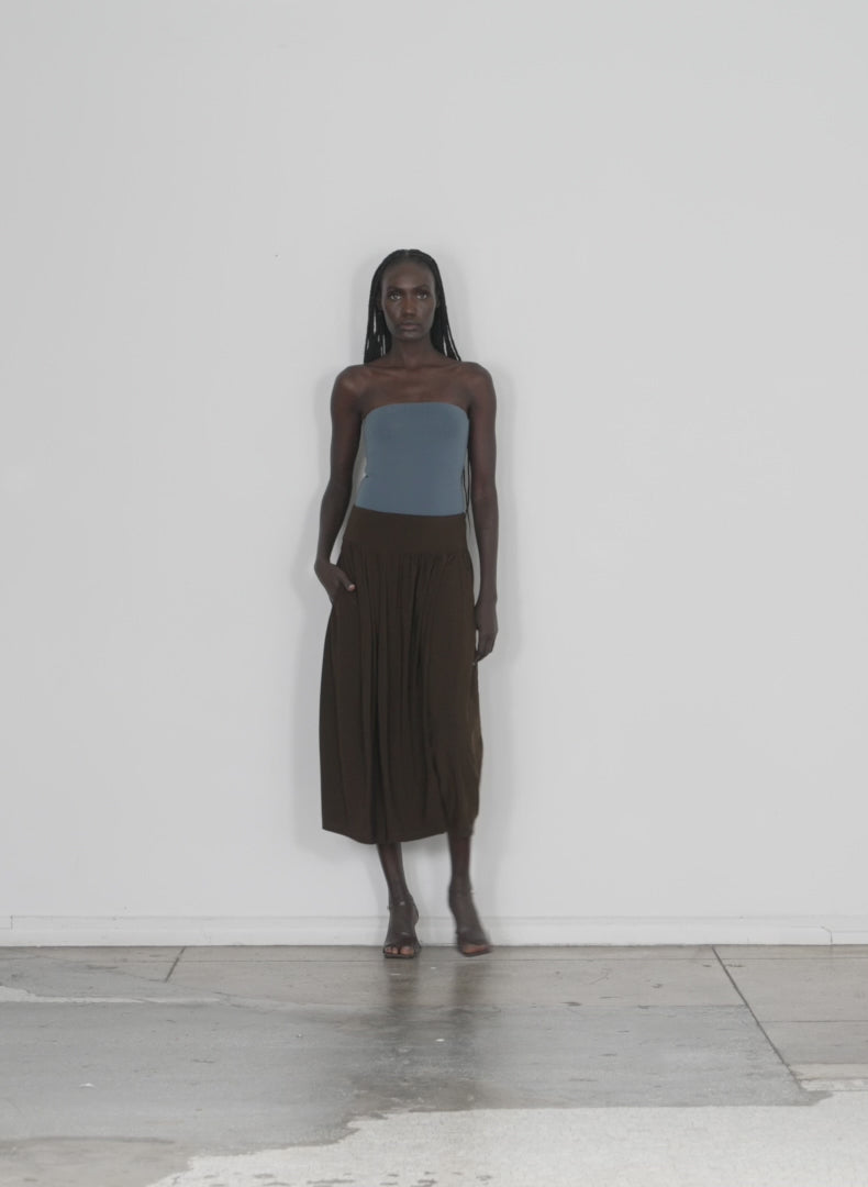 Model wearing the drapey jersey lantern skirt brown walking forward and turning around