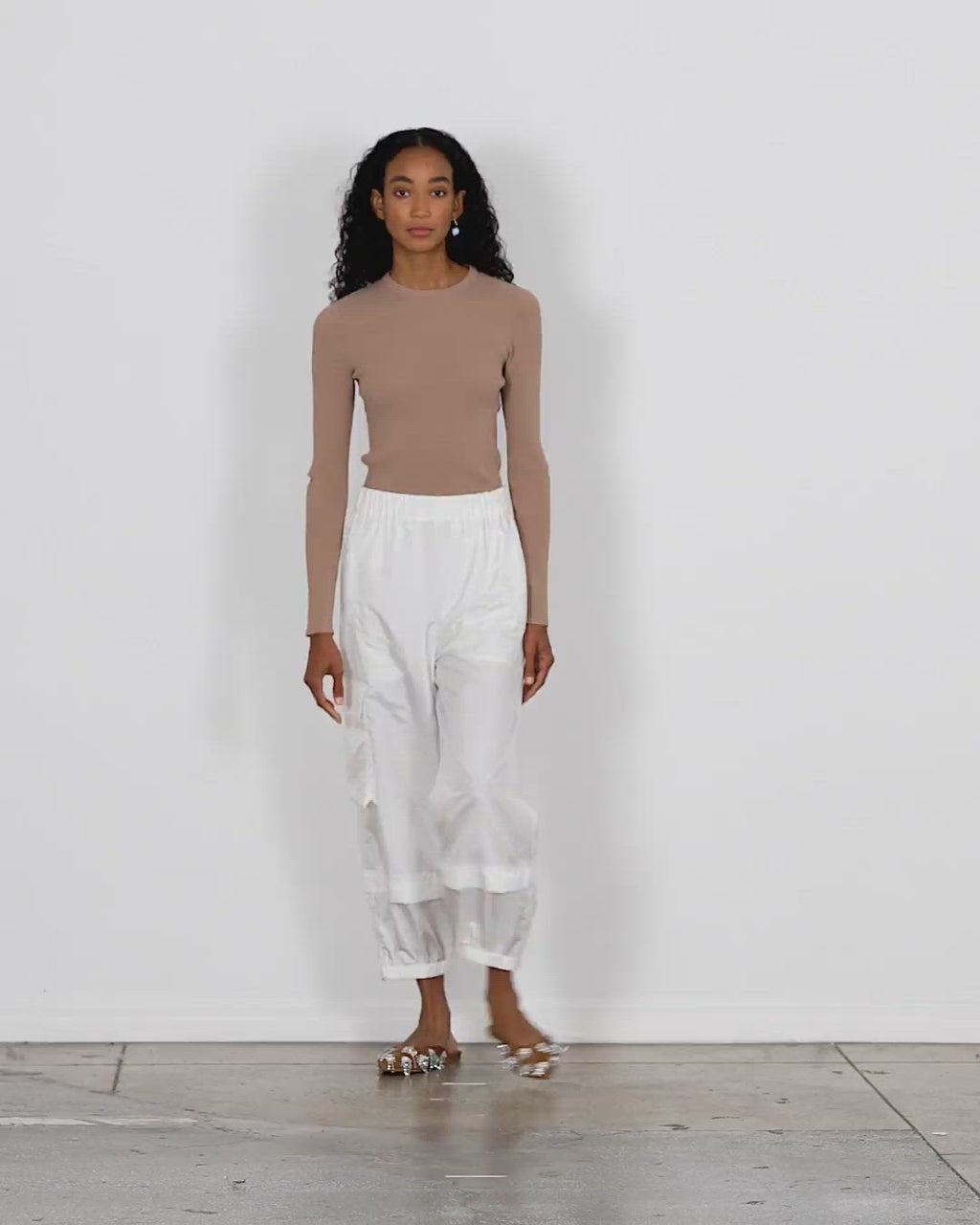 Model wearing the giselle slash cutout crewneck pullover sand brown walking forward and turning around