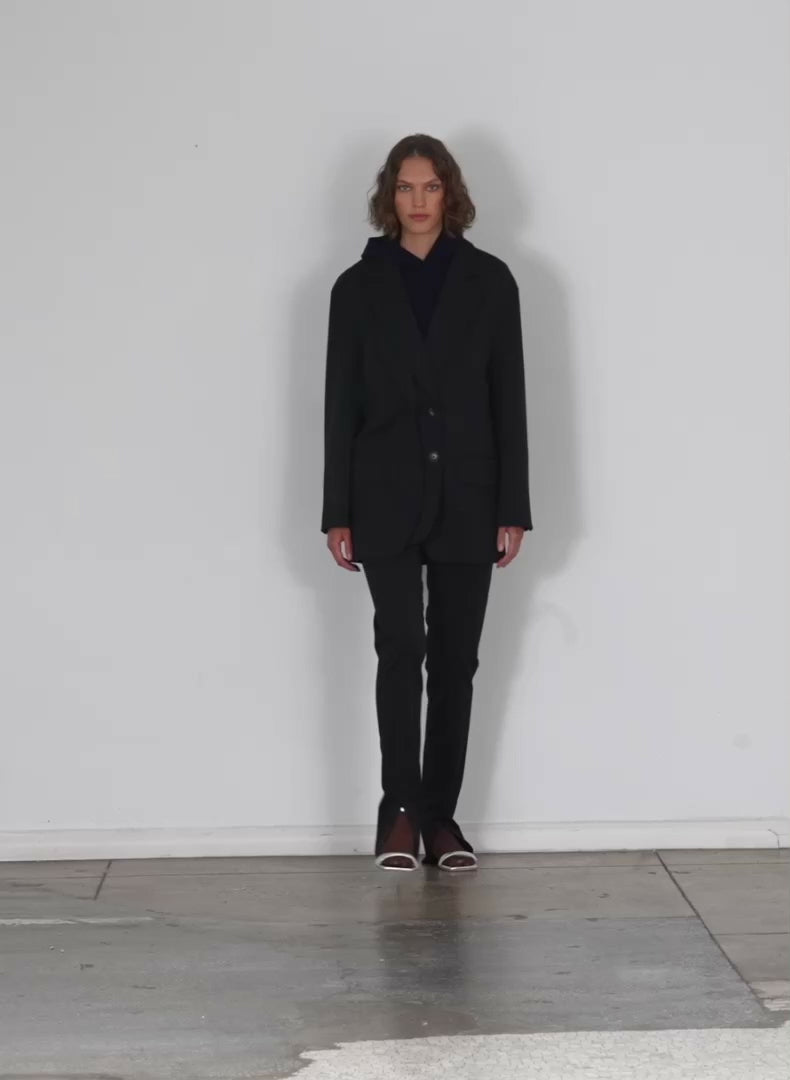 Model wearing the cassius suiting dbl layer liam blazer black walking forward and turning around
