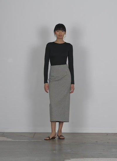 Model wearing the menswear tailored jersey pencil skirt walking forward and turning around