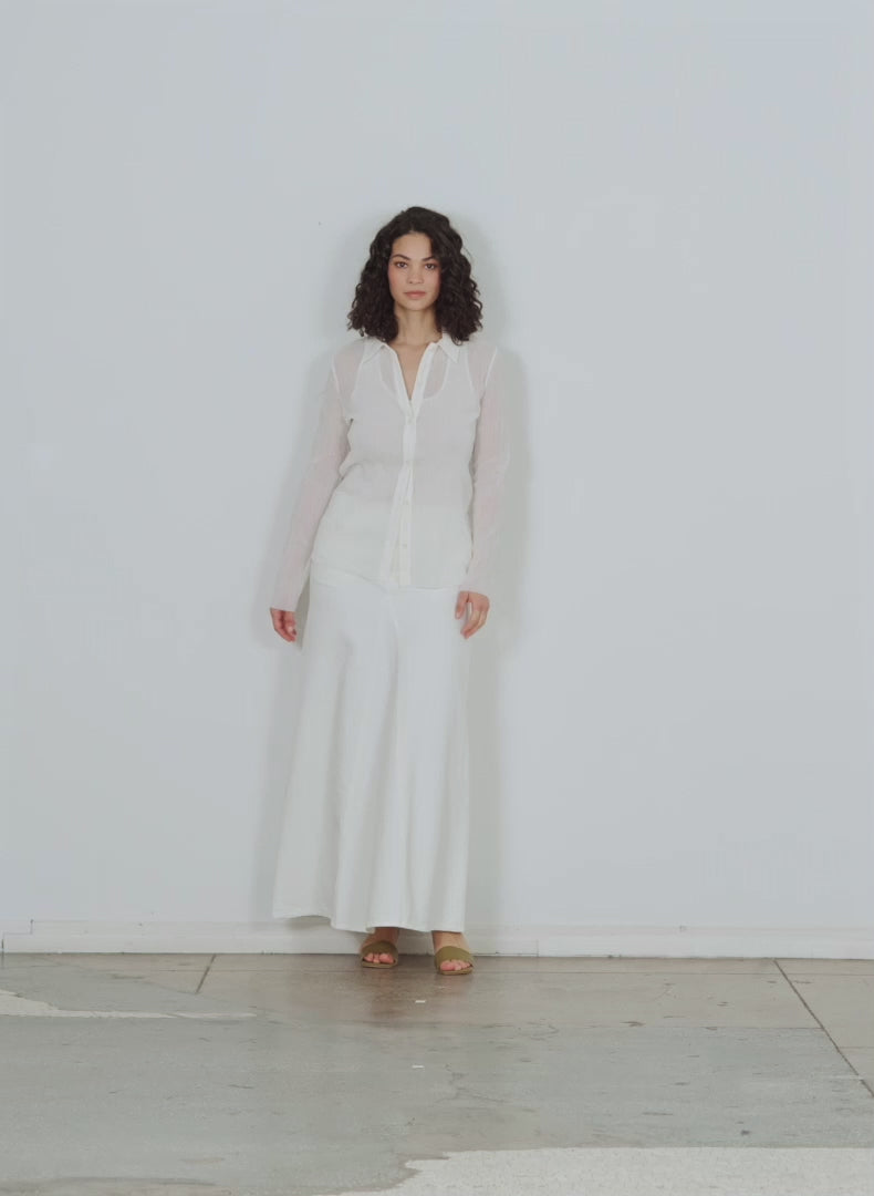 Model wearing the white denim godet maxi skirt white walking forward and turning around