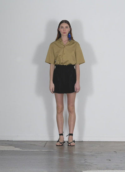 Model wearing the eco poplin camp shirt khaki walking forward and turning around