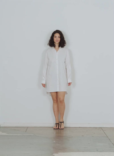 Model wearing the eco poplin new twisted slv dress white walking forward and turning around