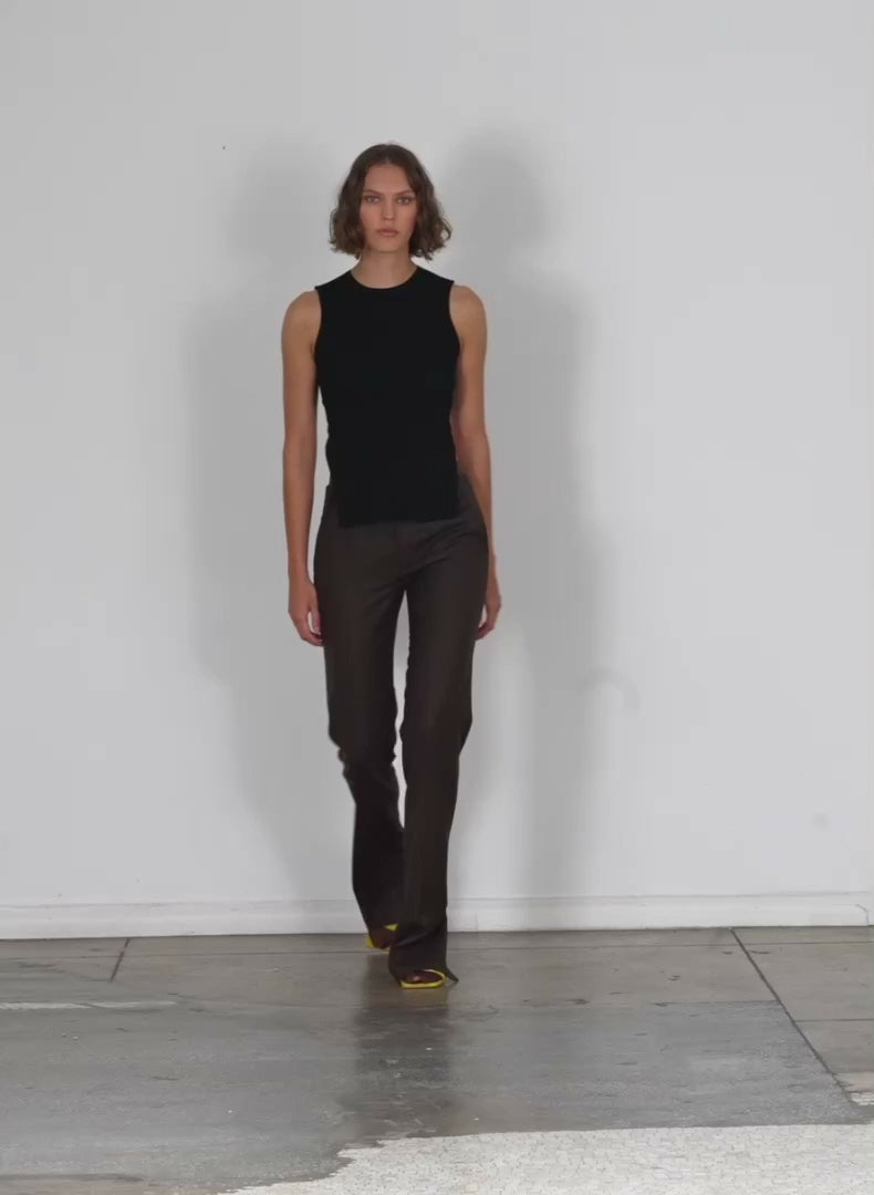 Model wearing the giselle stretch sweater circle openback tank black walking forward and turning around