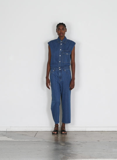 Model wearing the stone washed denim sleeveless easy shirt medium stone wash walking forward and turning around