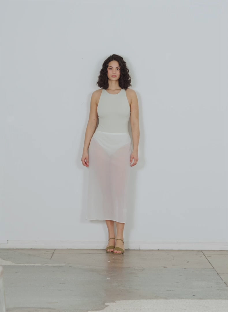 Model wearing the sheer gauze maxi pencil skirt white walking forward and turning around